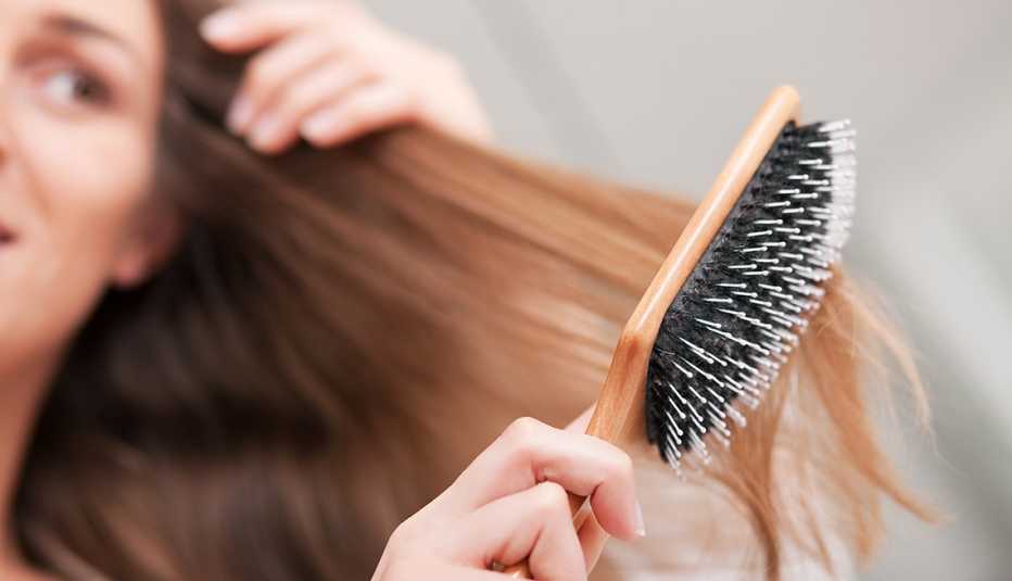 Mujer cepillándose el cabello con suavidad - Cuidado capilar Ybera Paris